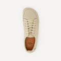 A single low-top barefoot dance sneaker shown from a top-down view on a light gray background. The shoe is beige with matching beige laces and a tan interior lining featuring the 'Dea Dux' brand logo.