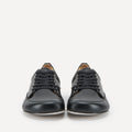 A pair of black leather low-top lace-up barefoot dance sneakers with a broad rounded toe box, photographed from the front against a clean white background.